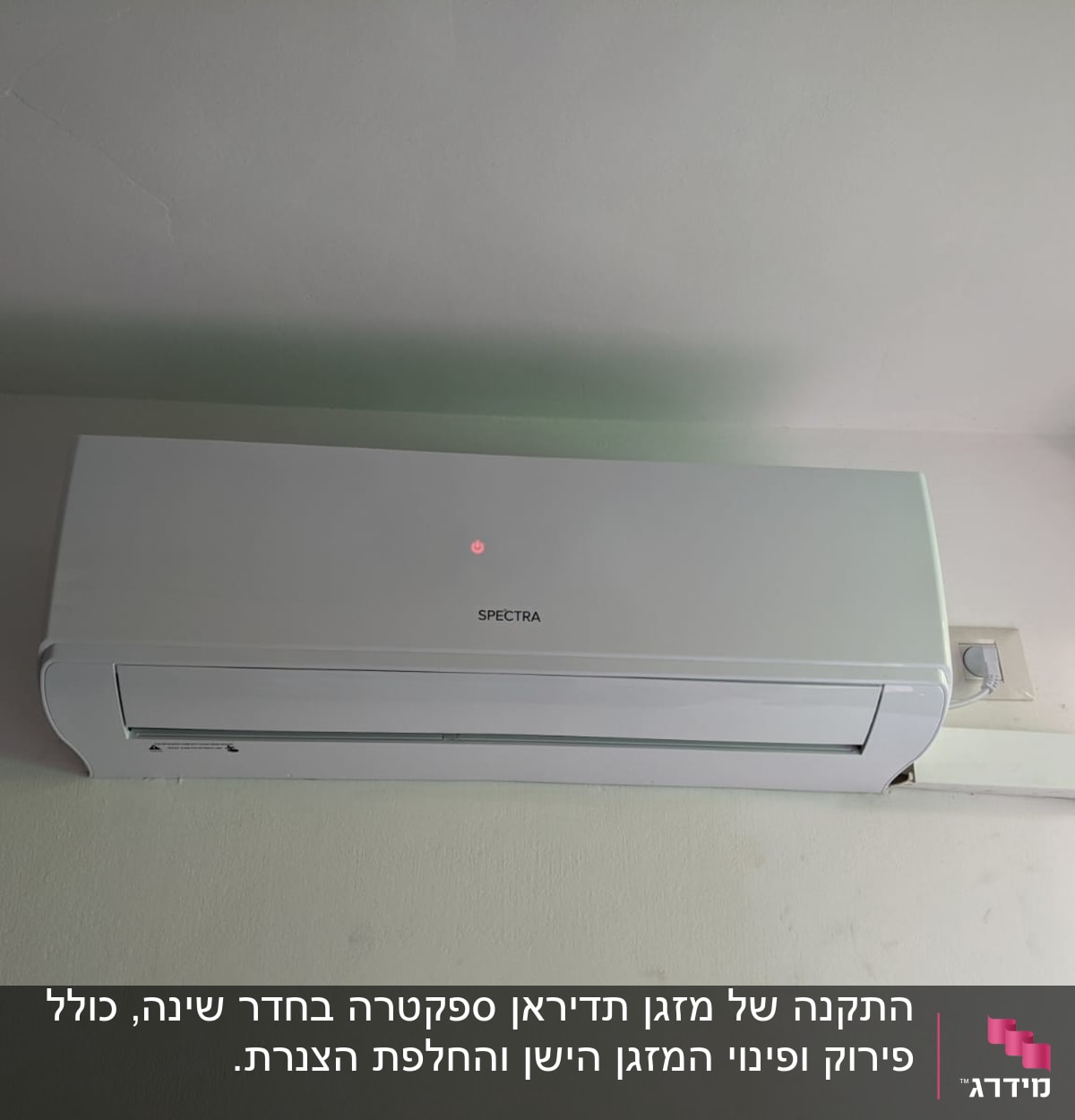 מזגן קיר לבן מותקן על קיר עם שלט אדום